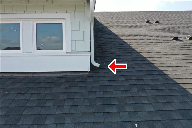 Downspouts discharging onto shingles.